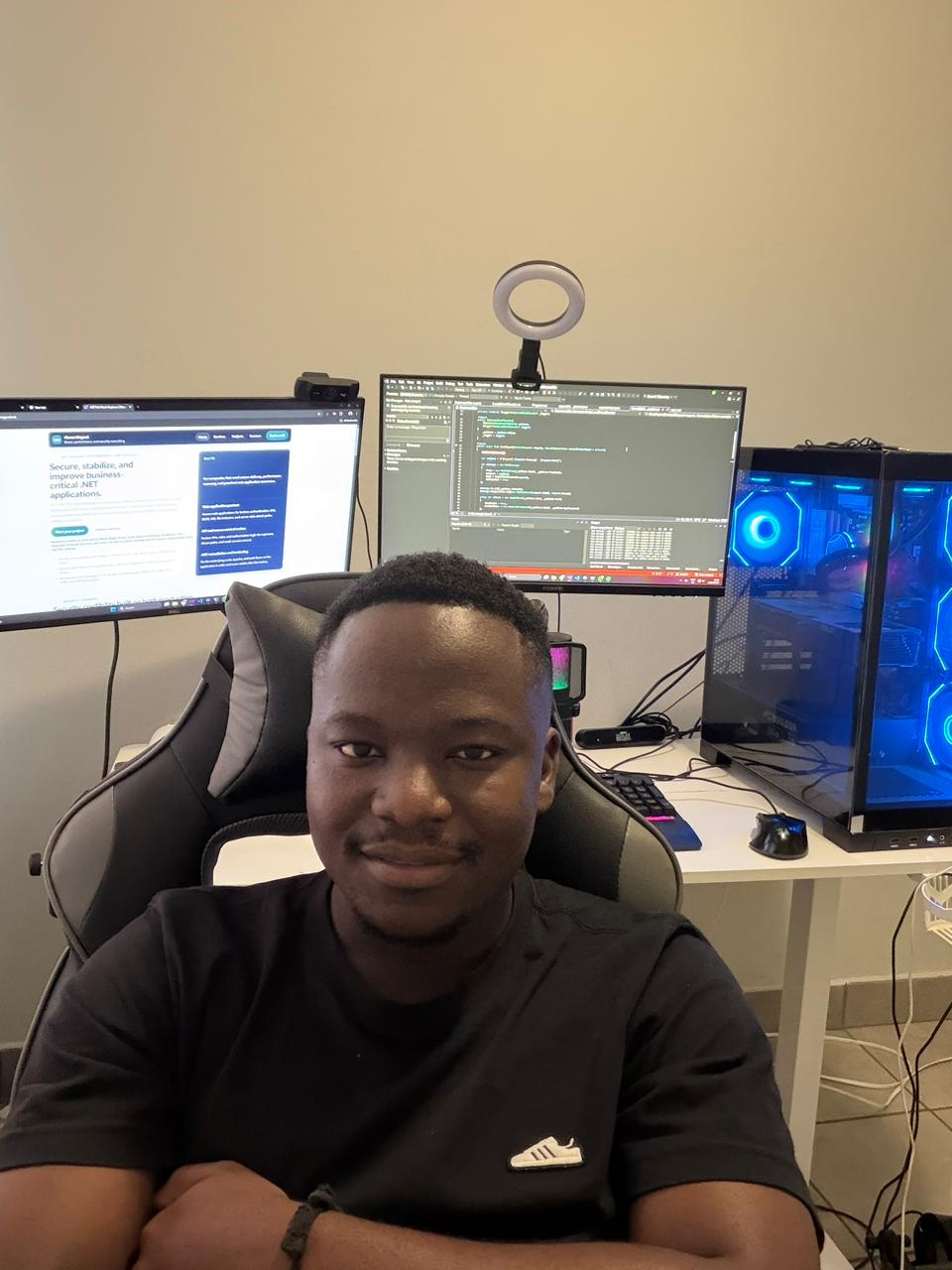 Abram Magwai at a multi-monitor development workspace